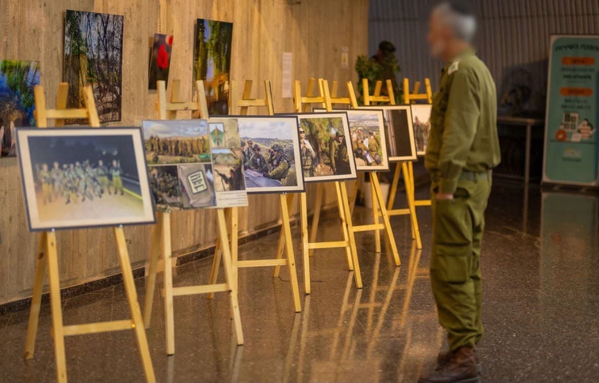 קצין צופה בתערוכת תמונות של לוחמים